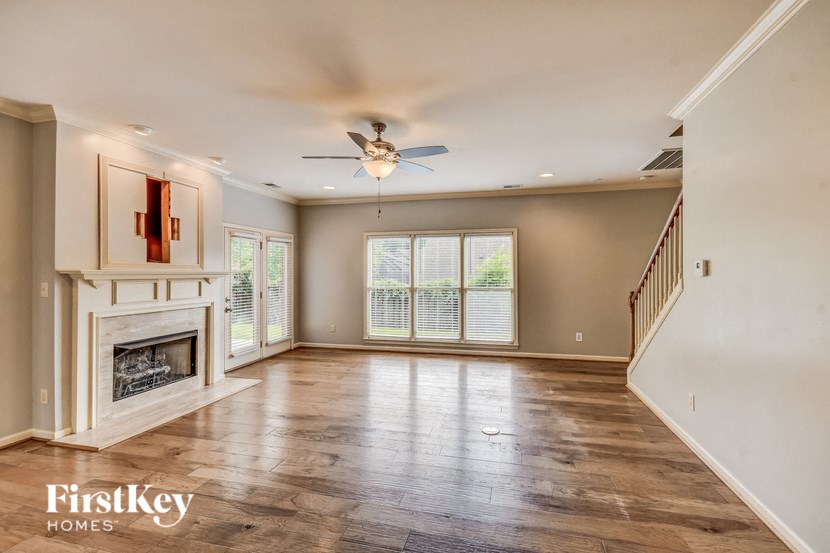 A spacious living room with a fireplace and wood flooring.