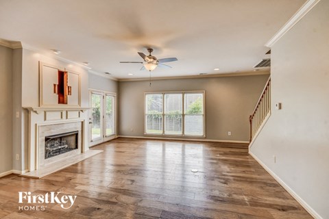 A spacious living room with a fireplace and wood flooring.