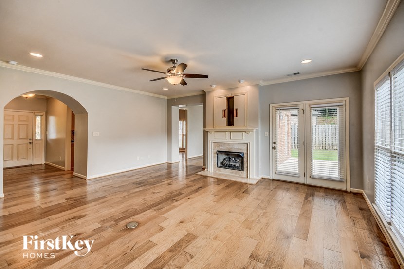 A spacious living room with wooden floors and a fireplace.