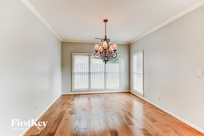 A room with wooden floors and a chandelier hanging from the ceiling.