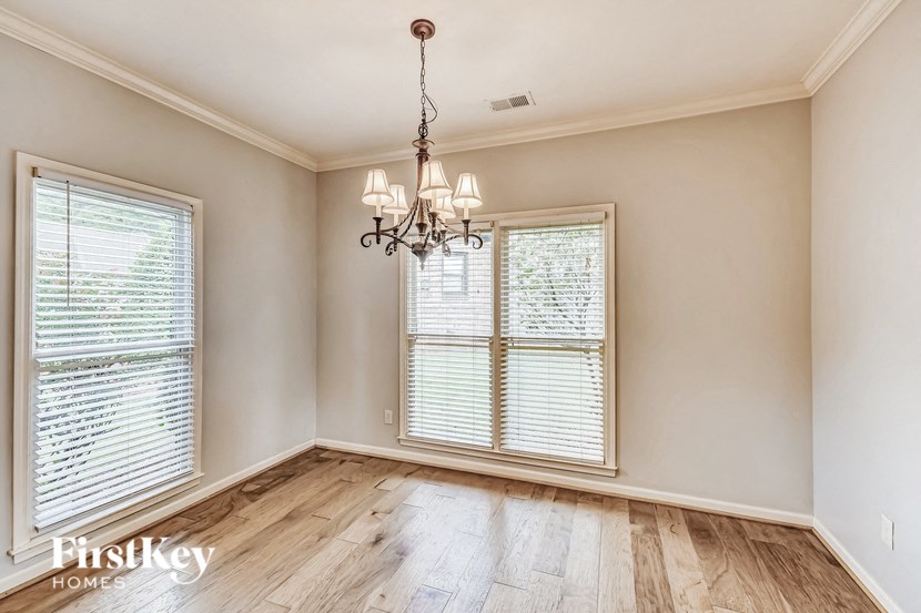 A room with wooden floors and a chandelier hanging from the ceiling.