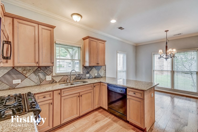 A kitchen with wooden cabinets and a granite countertop.