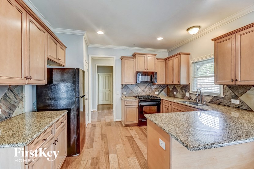 A kitchen with wooden cabinets and a granite countertop.
