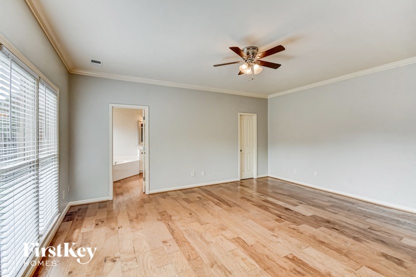 A room with wooden floors and a ceiling fan.