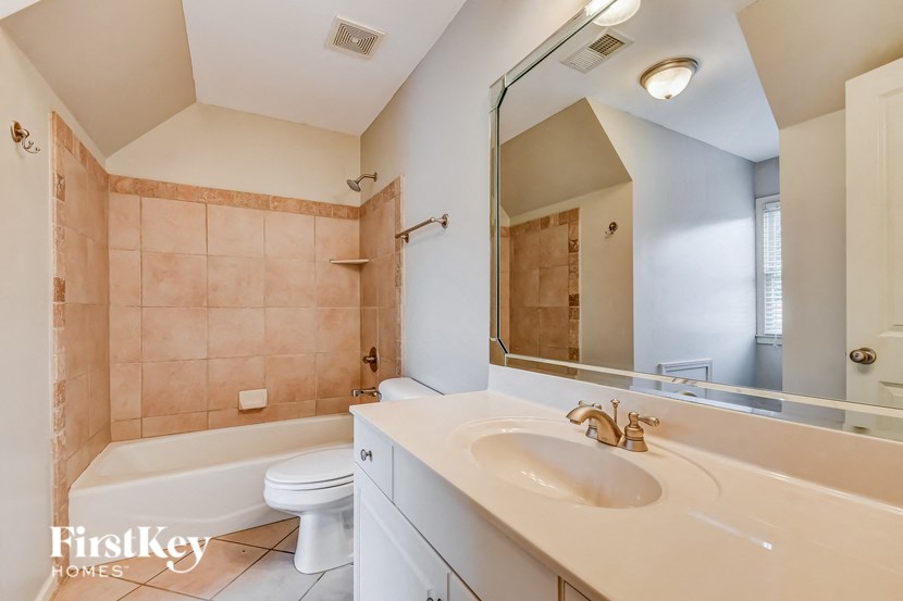 A bathroom with a tub, toilet, and sink.