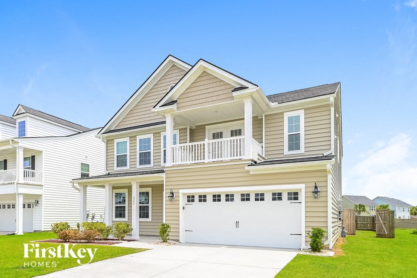 A two-story house with a garage is showcased in the image.