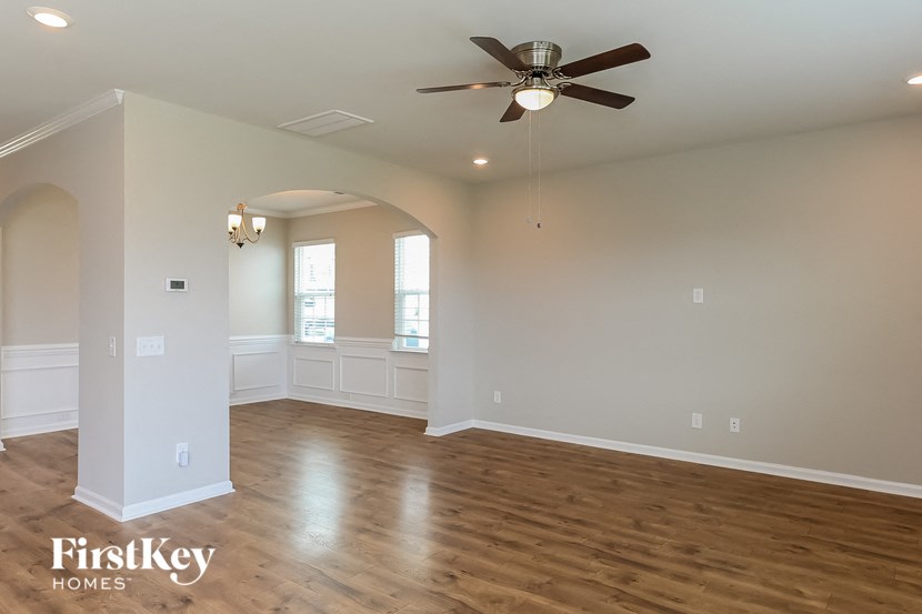 A spacious room with a ceiling fan and wooden flooring.
