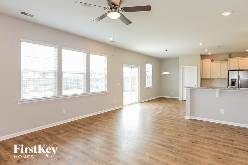 A spacious room with a ceiling fan and wooden flooring.