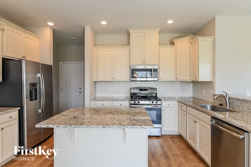 A kitchen with granite countertops and stainless steel appliances.