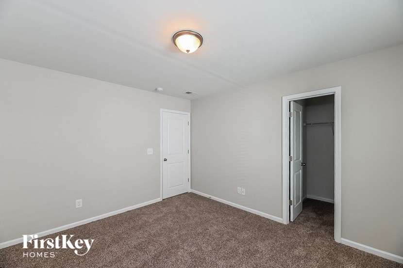 A room with a carpeted floor and a door on the right.