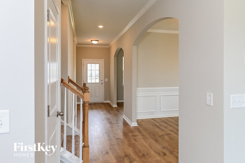 A hallway with a wooden staircase and white walls.