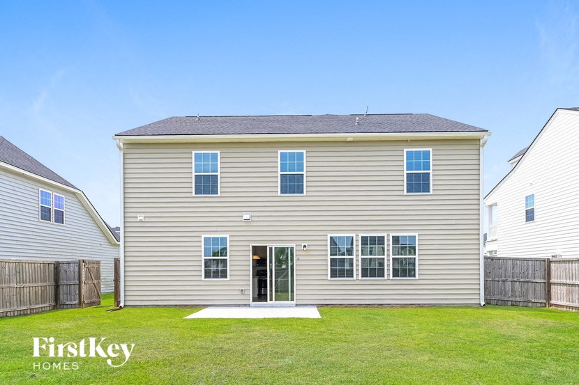 A two-story house with a garage on the first floor and a balcony on the second floor.