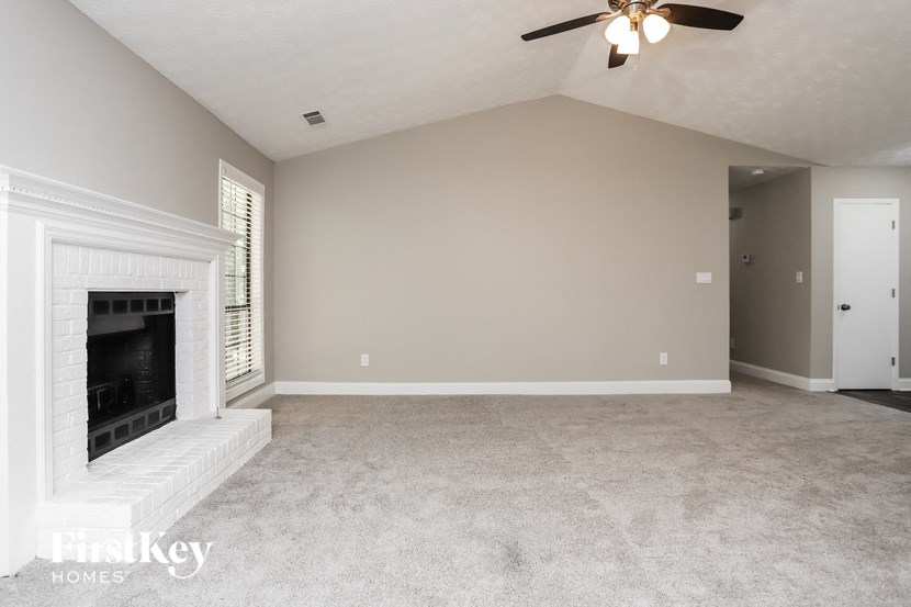 a living room with a fireplace and a ceiling fan