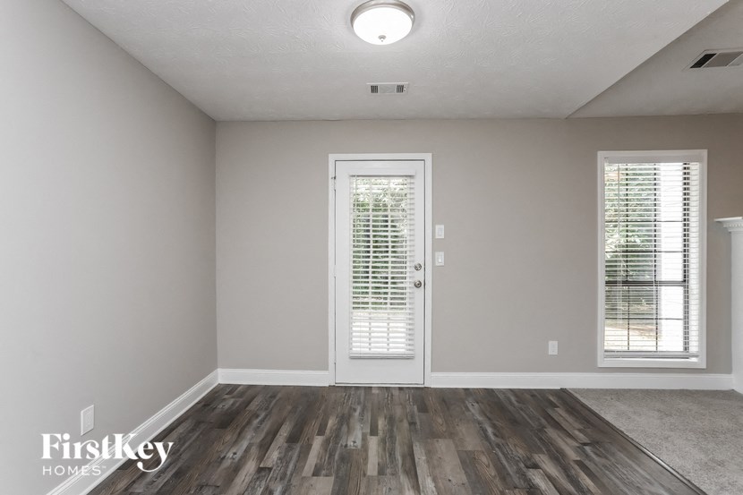 an empty living room with a door and window