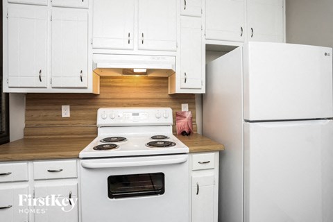 a white kitchen with white appliances and white cabinets
