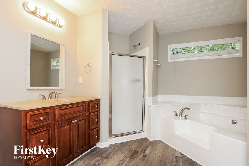 a bathroom with a tub and a sink and a shower