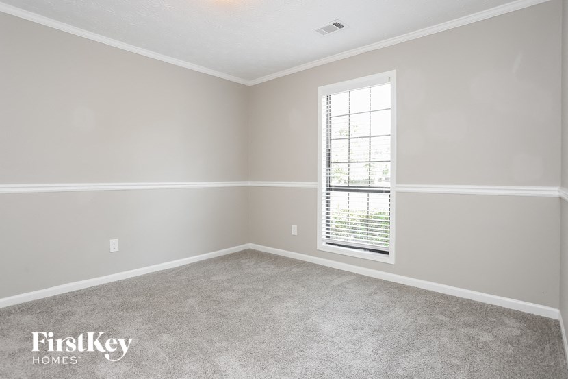 an empty room with a window and carpet