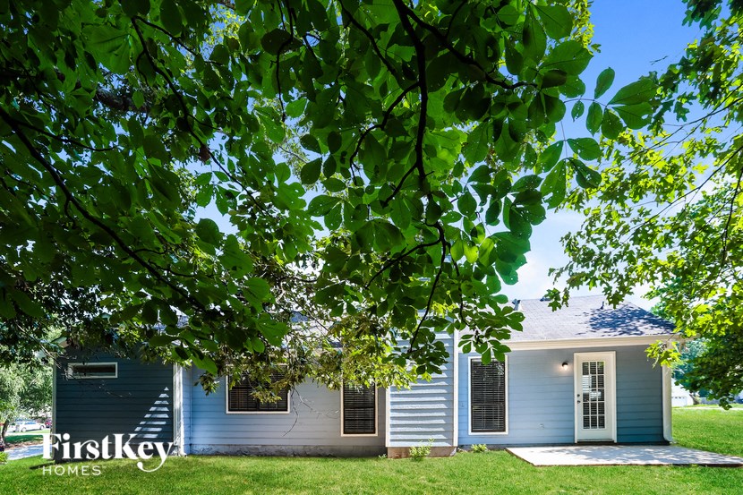 a blue and white house with a tree in front of it