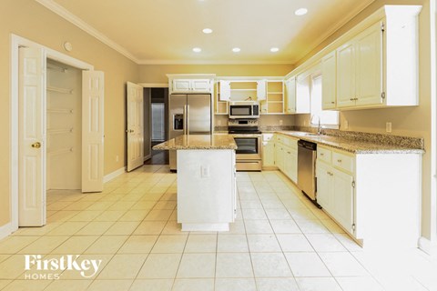 A kitchen with white appliances and cabinets is shown.