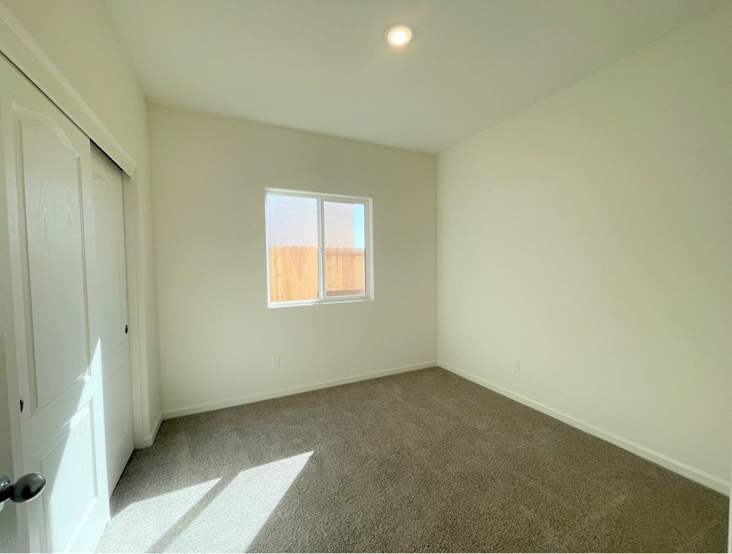a room with carpet and a window and a closet