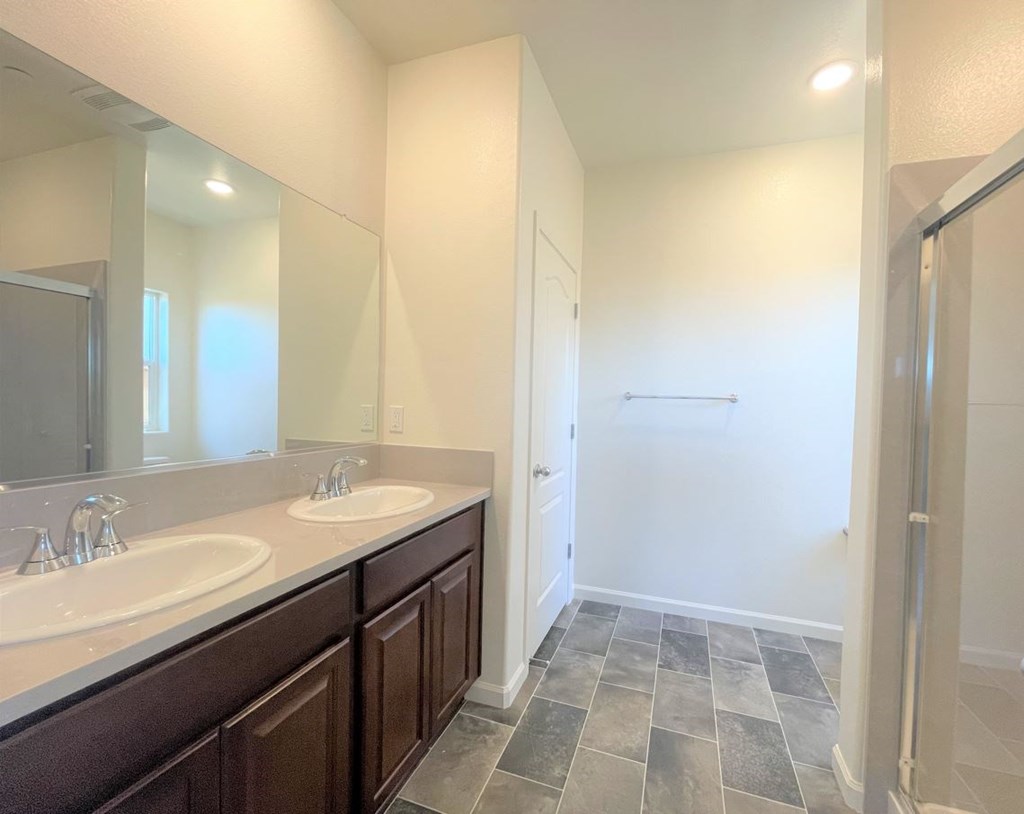 a bathroom with two sinks and a shower