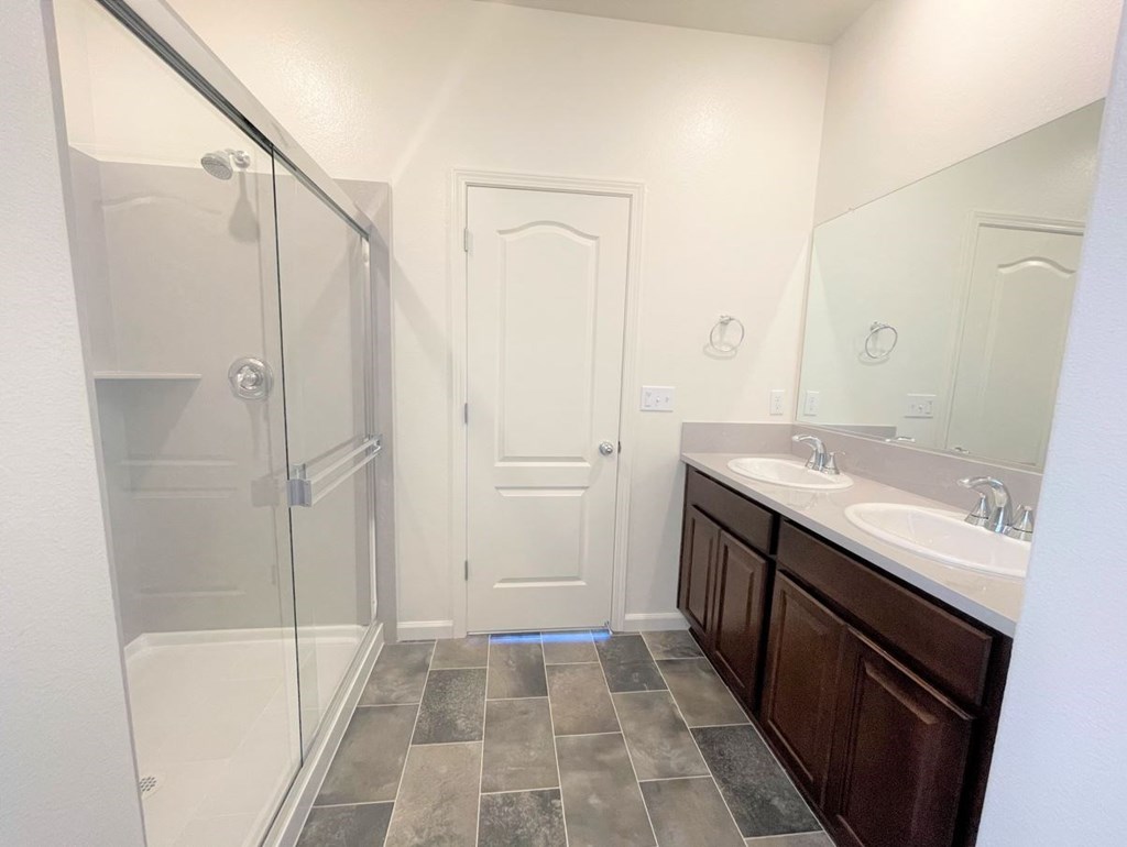 a bathroom with two sinks and a shower