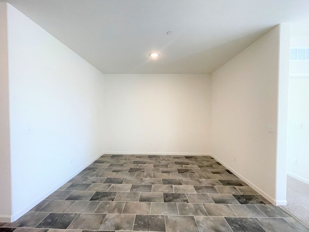 an empty room with white walls and a tiled floor