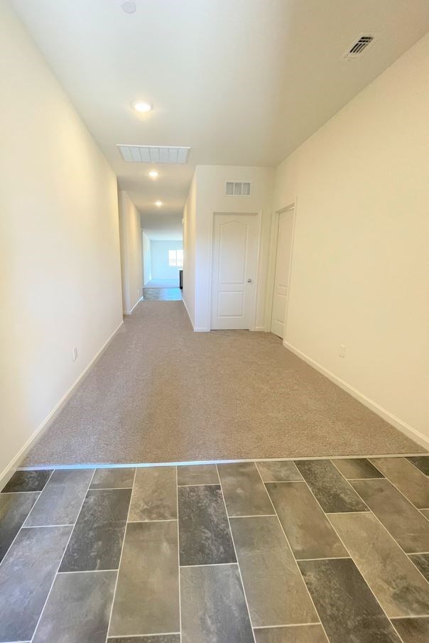 an empty living room with tile flooring and white walls