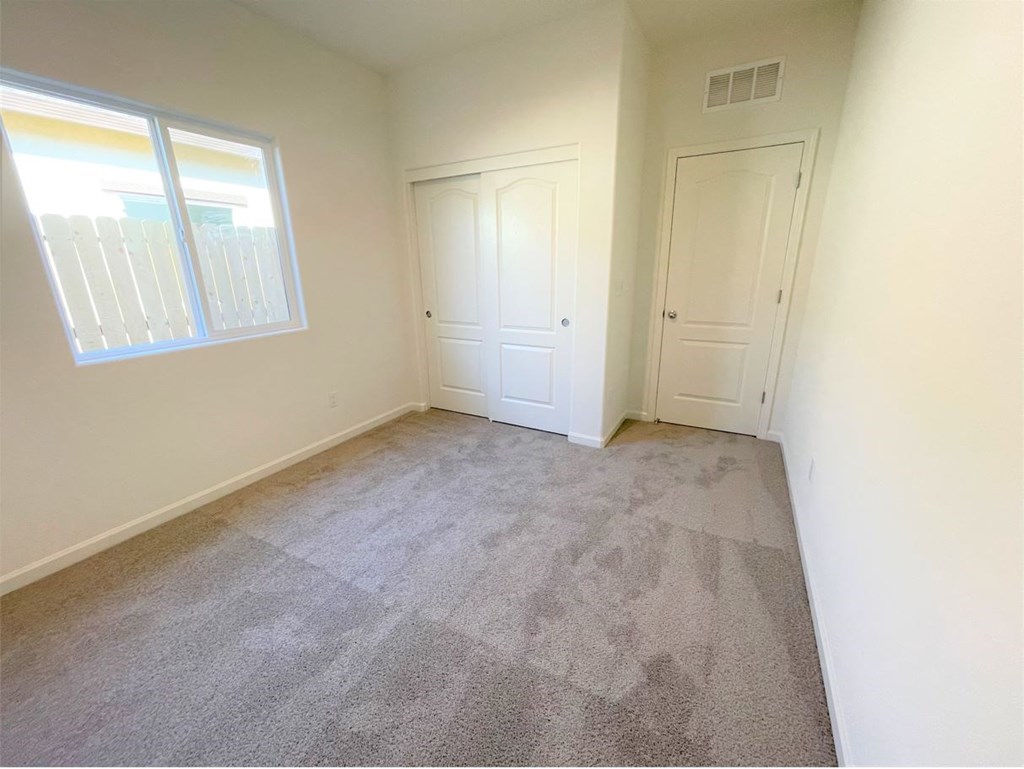 a bedroom with carpeted flooring and a window