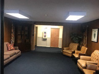 a living room with couches and chairs and a door