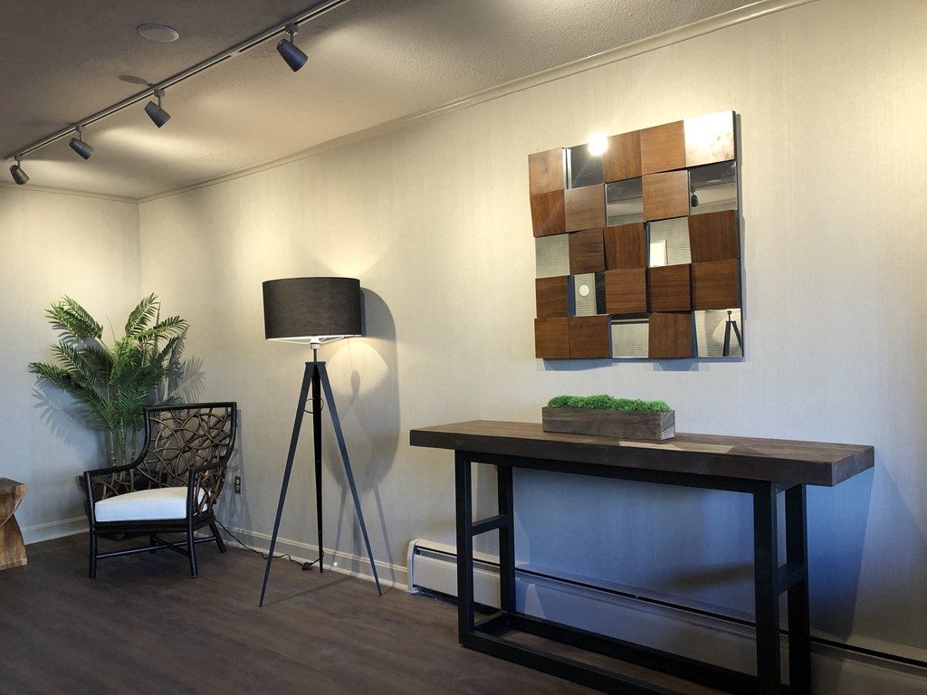 a living room with a table with a lamp and a painting on the wall
