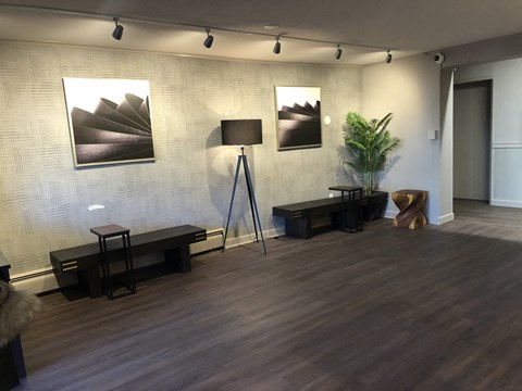 a living room with a wooden floor and paintings on the wall