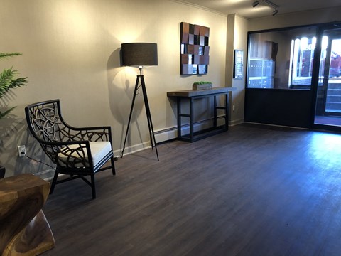 a living room with a tripod lamp and a chair