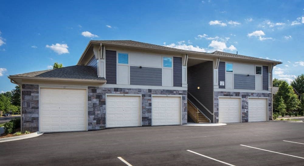 a house with three garage doors in a parking lot