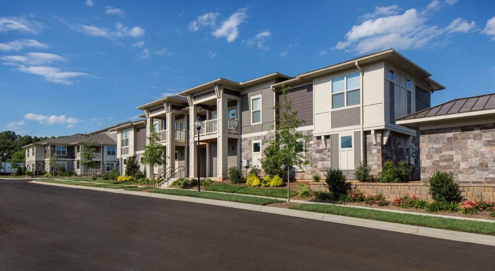 a row of apartment buildings on the side of a street