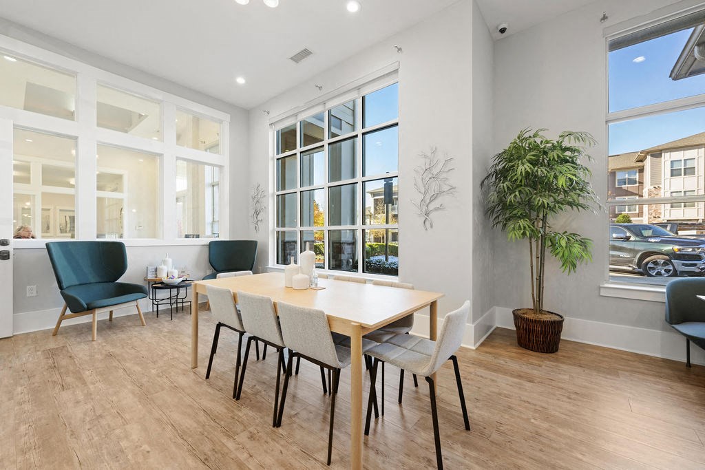 A room with a table and chairs and a potted plant.