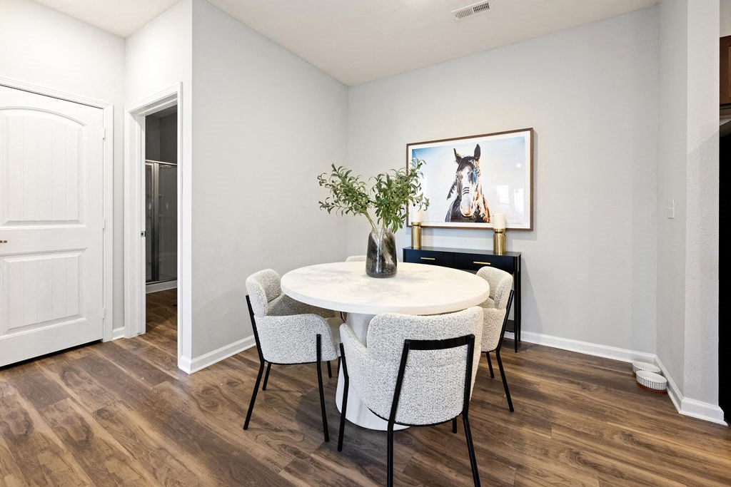 A dining room with a white table and chairs.