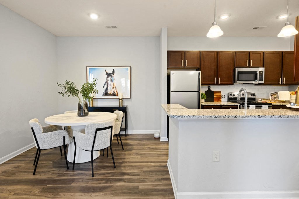 A kitchen with a table and chairs and a painting of a horse on the wall.