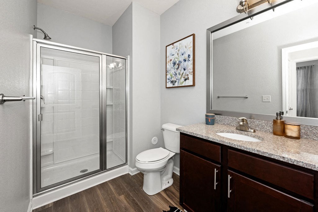 A bathroom with a toilet, sink, and shower.