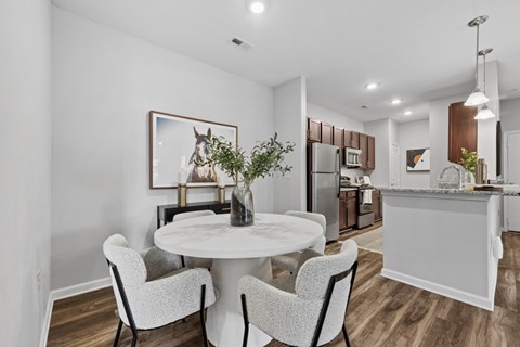 A modern kitchen with a dining table set for two.