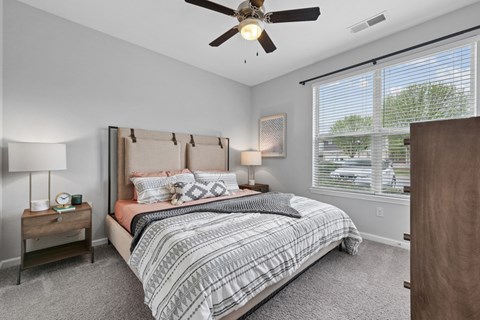 A bedroom with a large bed and a ceiling fan.