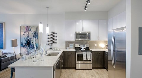 A modern kitchen with a large island and stainless steel appliances.
