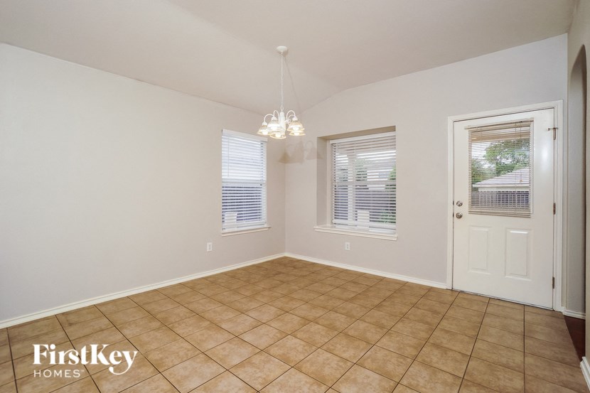 the dining room of a home with a tiled floor and a white door