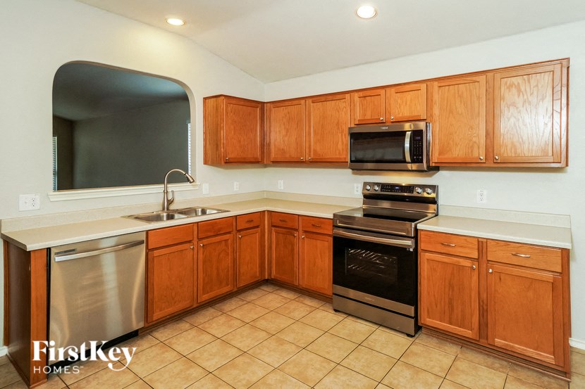 a kitchen with wooden cabinets and stainless steel appliances