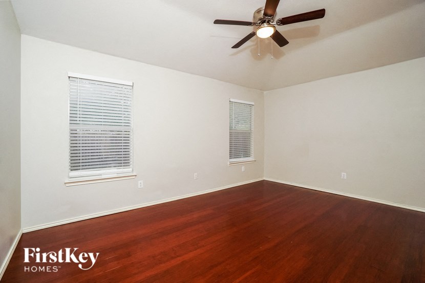 a living room with wood floors and a ceiling fan