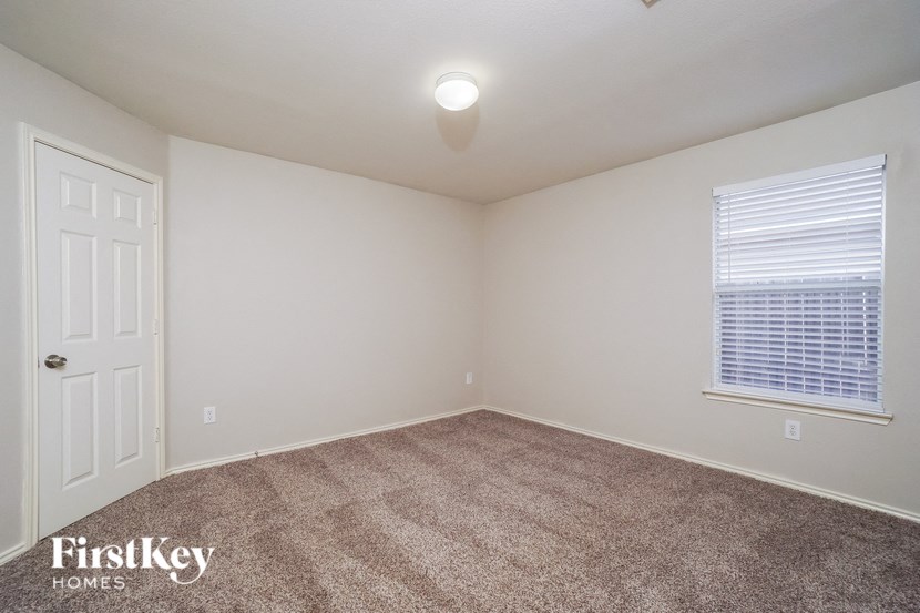 a room with carpet and a window and a white door