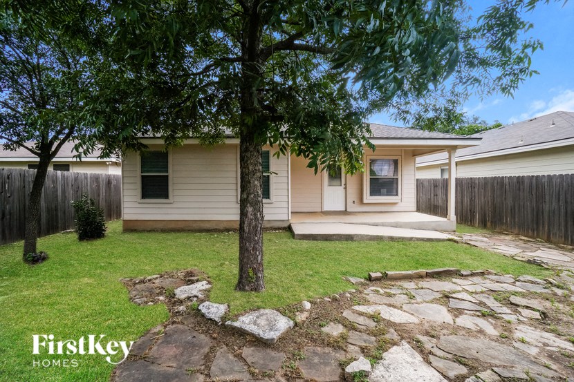 a small white house with a tree in the yard