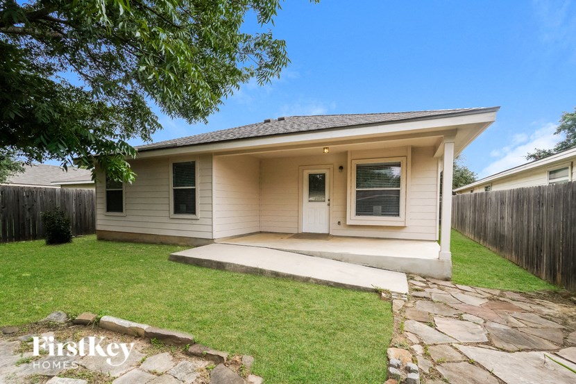 a small white house with a yard and a sidewalk