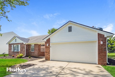 a white garage door in front of a brick house
