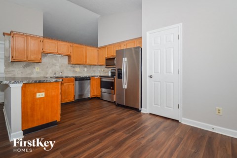 a kitchen with wooden cabinets and stainless steel appliances and a door